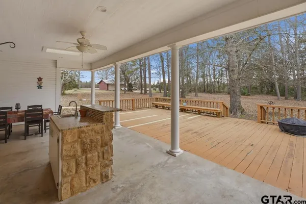 a view of a patio with table and chairs with wooden floor and fence