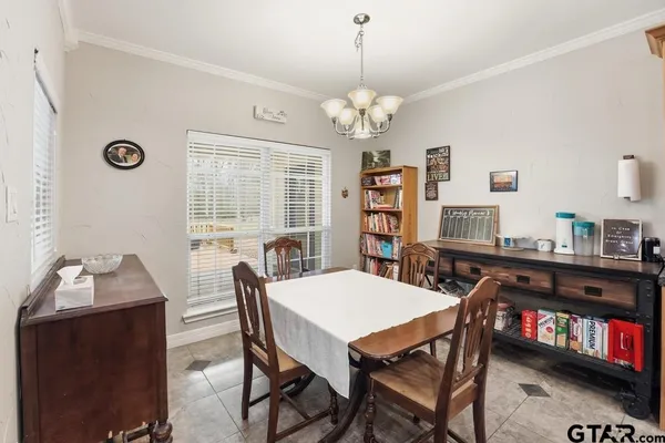 a view of a dining room with furniture and a chandelier