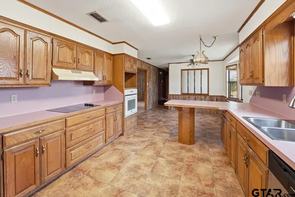 a view of an empty room with a window and hardwood