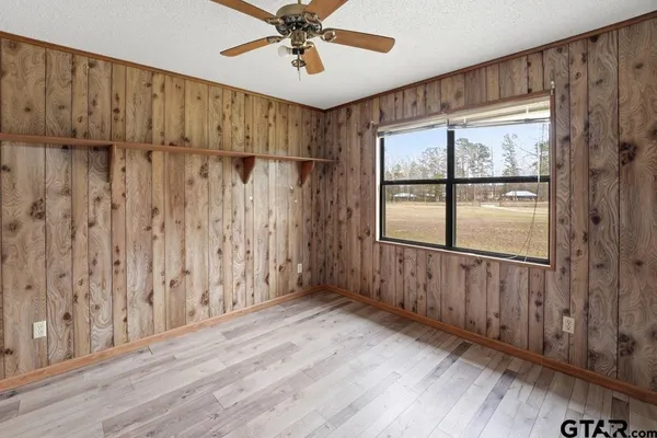 a view of a big room with chandelier fan and windows