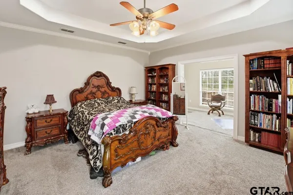 a bed sitting in a bedroom next to a bookshelf