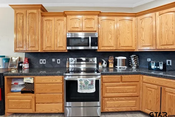 a kitchen with stainless steel appliances granite countertop a stove and a microwave