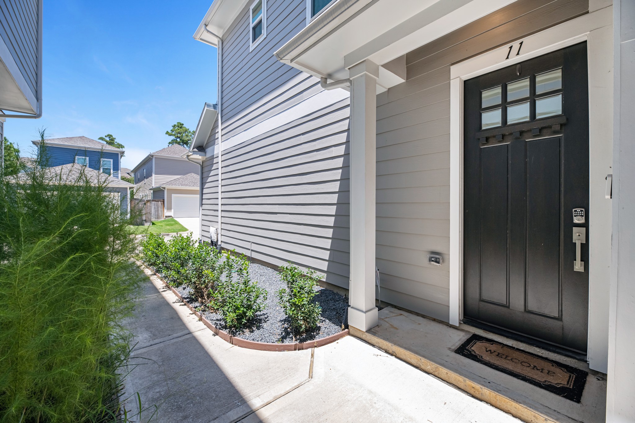 11 Thorpe Lane Spring, TX 77389 - Photo 4 of 34 Charming side entrance features a welcoming pathway leading to the front door, surrounded by clean, low-maintenance landscaping for easy curb appeal.