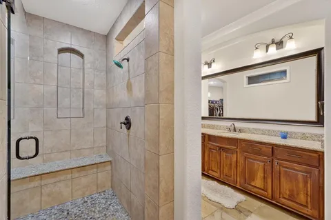 a bathroom with a shower sink and mirror