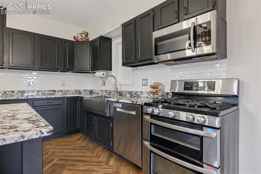 17940 Appaloosa Road Monument, CO 80132 - Photo 13 of 44 a kitchen with stainless steel appliances granite countertop a stove microwave and cabinets