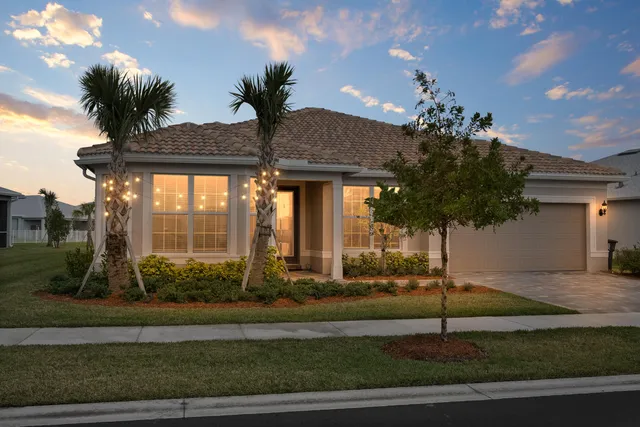 a view of a house with a yard and potted plants