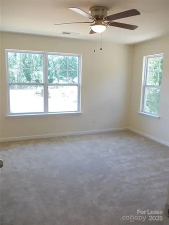 an empty room with a window and a fan