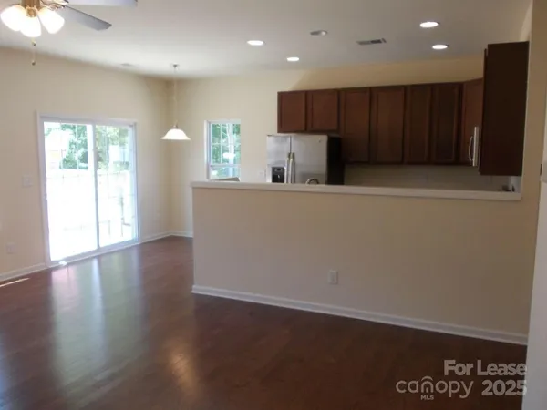 an open kitchen with wooden floor and large window