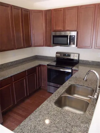 a kitchen with wooden cabinets a sink and a stove
