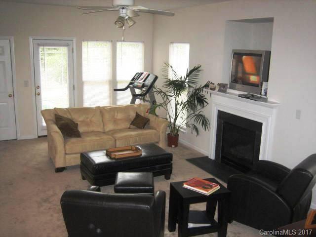 8825 Washam Potts Road Cornelius, NC 28031 - Photo 3 of 3 a living room with furniture a fireplace and a flat screen tv