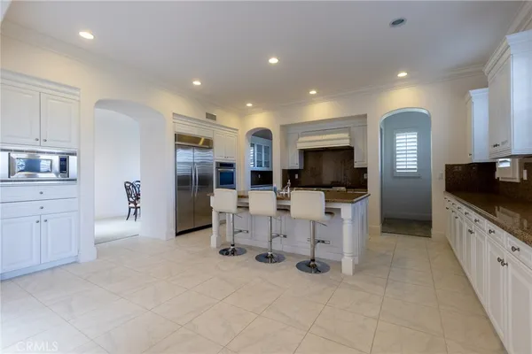 a large white kitchen with white cabinets and stainless steel appliances