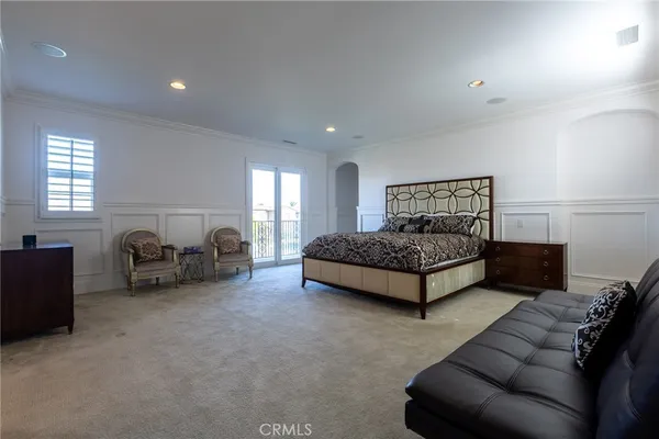 a spacious bedroom with a bed and couch