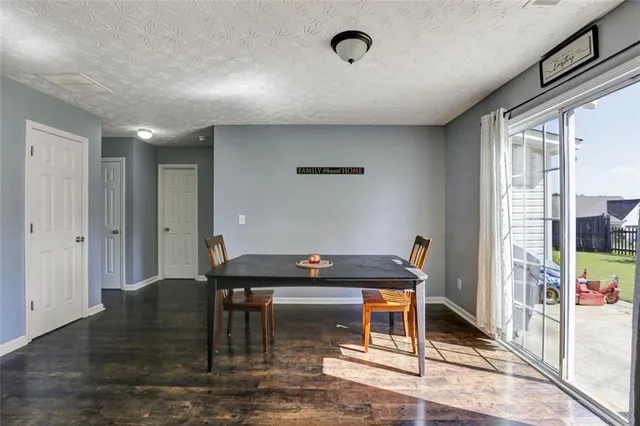 a living room with a table and chairs and wooden floor
