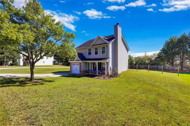 a view of a house with pool and a yard