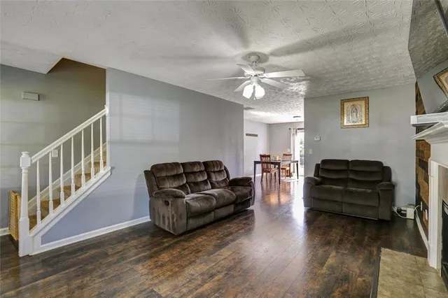 a living room with furniture and a ceiling fan
