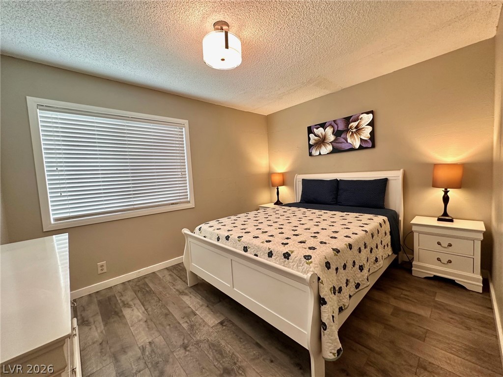 2340 Viewcrest Road Henderson, NV 89014 - Photo 26 of 36 This inviting bedroom features rich flooring and a large window for a peaceful retreat.