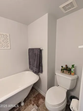 a white toilet sitting next to a bath tub