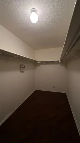 a view of an empty room with window and chandelier fan