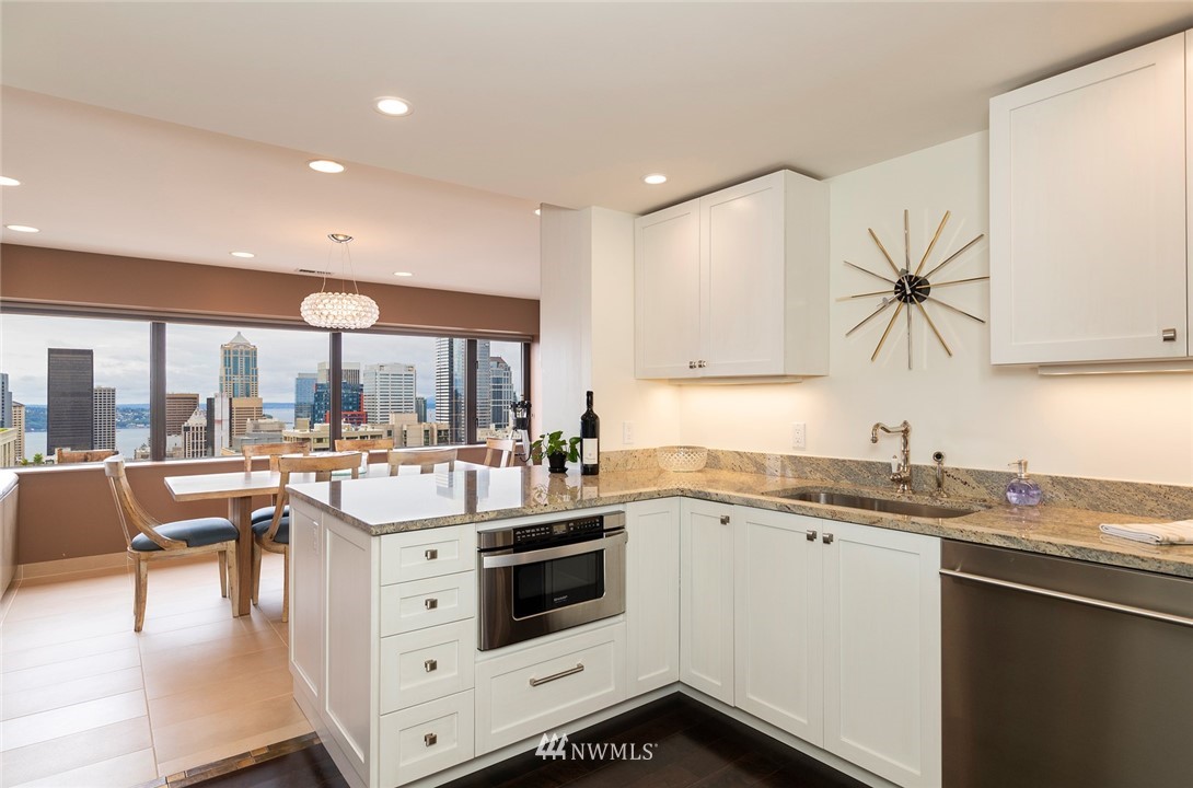 1301 Spring Street, Unit 18J Seattle, WA 98104 - Photo 11 of 25 a kitchen with a stove a sink and cabinets