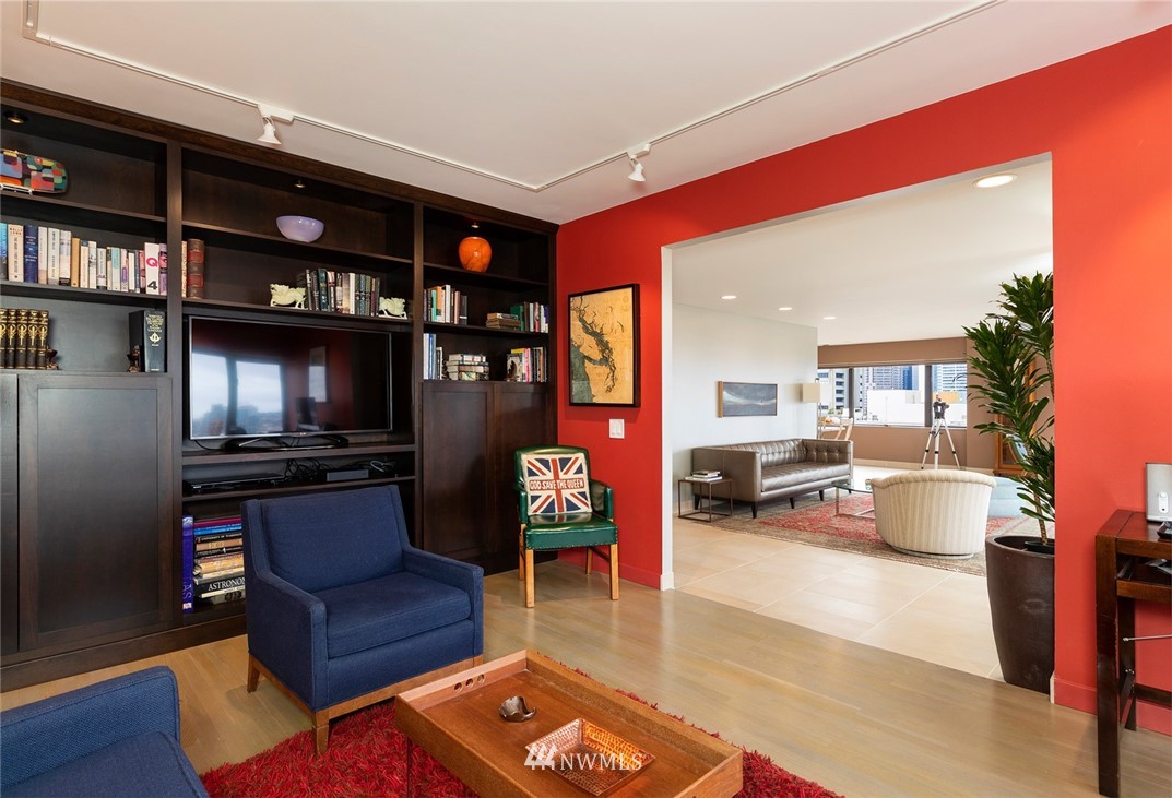 1301 Spring Street, Unit 18J Seattle, WA 98104 - Photo 12 of 25 a living room with furniture a rug and a bookshelf