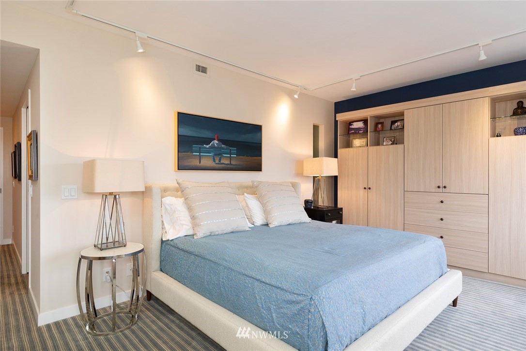 1301 Spring Street, Unit 18J Seattle, WA 98104 - Photo 14 of 25 a bedroom with a large bed a flat tv screen and dresser