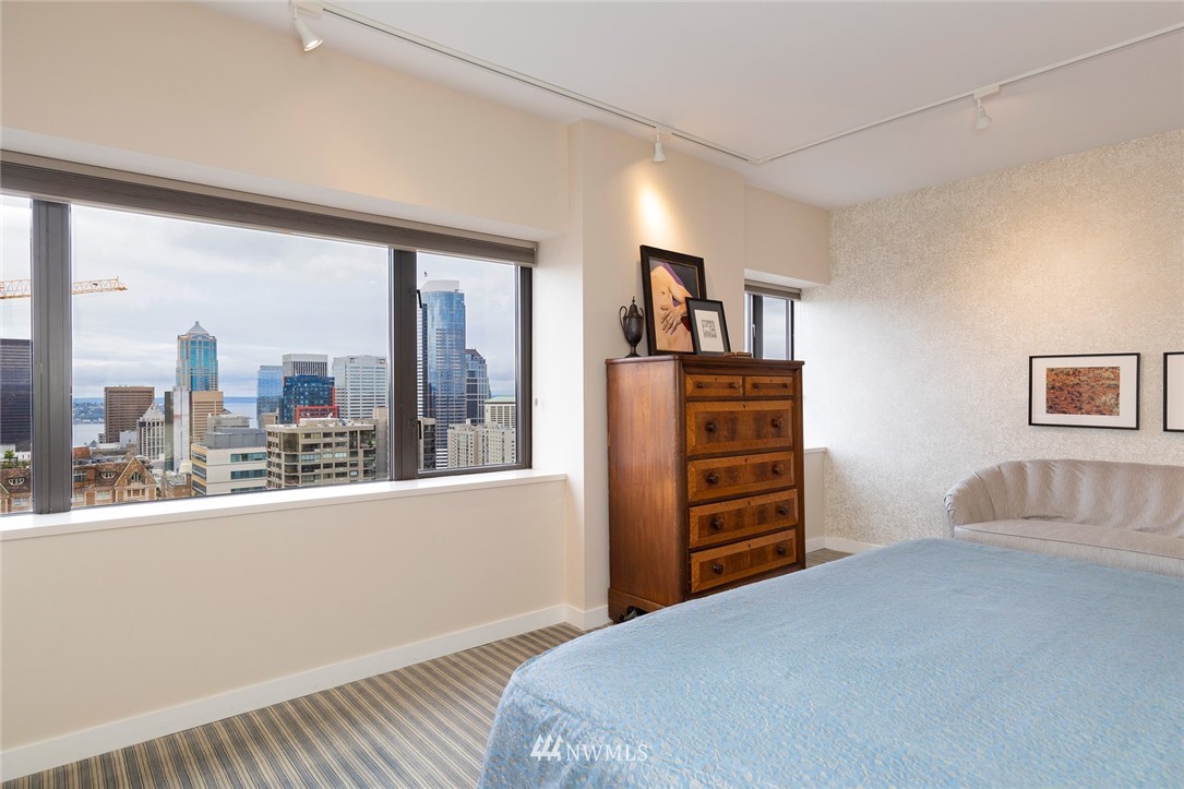 1301 Spring Street, Unit 18J Seattle, WA 98104 - Photo 15 of 25 a bedroom with a bed and a dresser next to a window