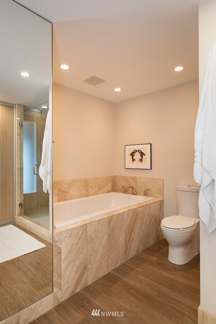 1301 Spring Street, Unit 18J Seattle, WA 98104 - Photo 17 of 25 a bathroom with a bathtub and a toilet