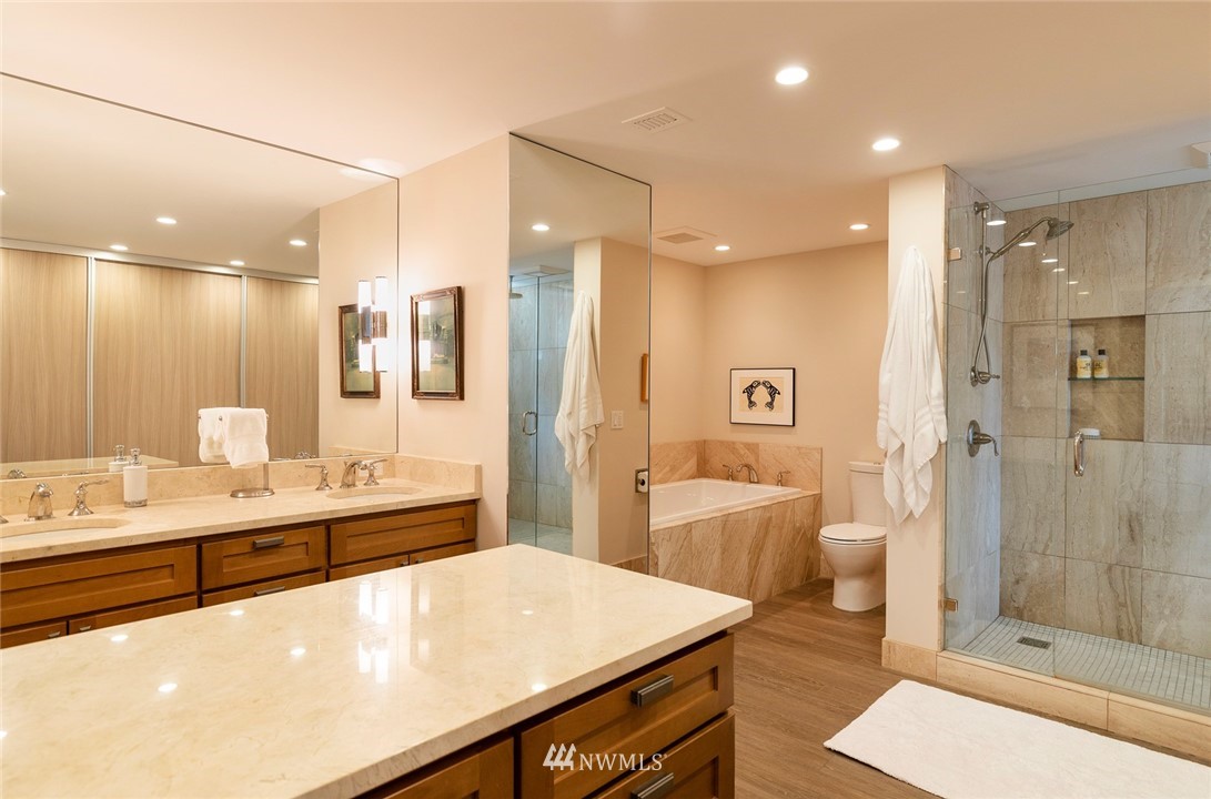 1301 Spring Street, Unit 18J Seattle, WA 98104 - Photo 18 of 25 a large bathroom with a sink a large mirror and a shower