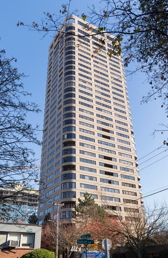 1301 Spring Street, Unit 18J Seattle, WA 98104 - Photo 3 of 25 a front view of a building with a yard