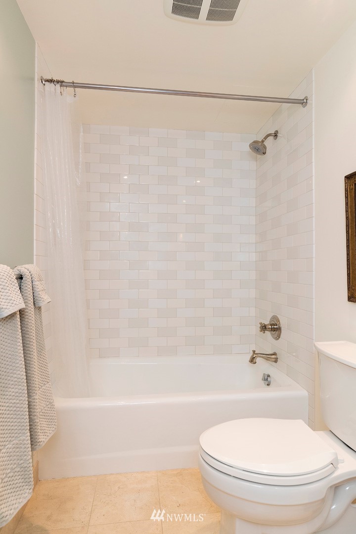 1301 Spring Street, Unit 18J Seattle, WA 98104 - Photo 21 of 25 a bathroom with a bathtub and a toilet
