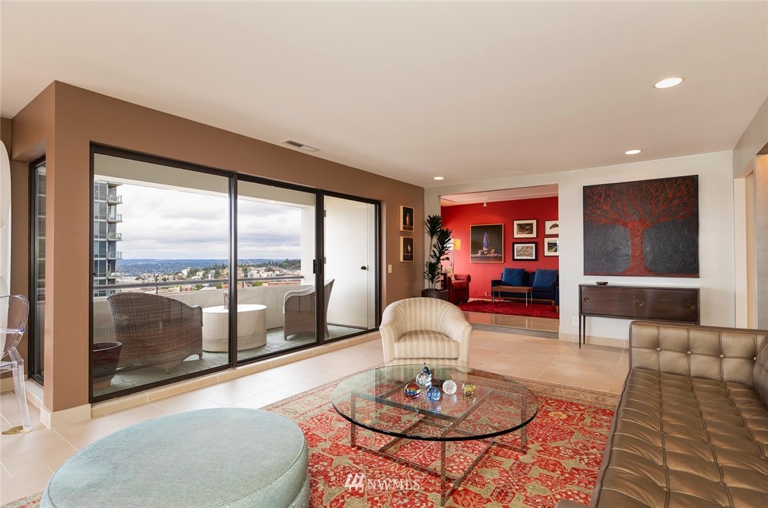 1301 Spring Street, Unit 18J Seattle, WA 98104 - Photo 5 of 25 a living room with furniture and a floor to ceiling window