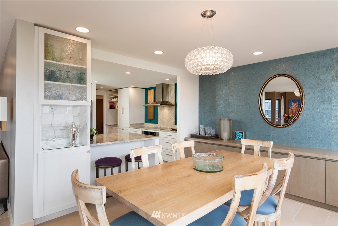 1301 Spring Street, Unit 18J Seattle, WA 98104 - Photo 8 of 25 a view of a dining room with furniture a chandelier and wooden floor
