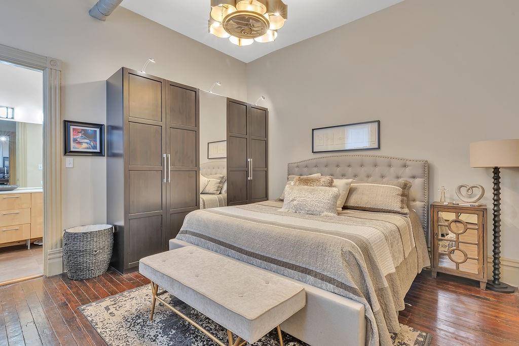 5202 Butler Street, Unit 1 Pittsburgh, PA 15201 - Photo 16 of 28 a bedroom with a bed a table and wooden floor