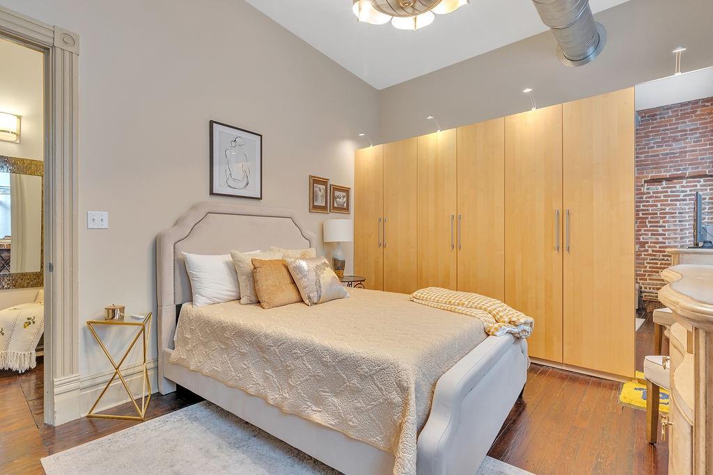 5202 Butler Street, Unit 1 Pittsburgh, PA 15201 - Photo 20 of 28 a bedroom with a bed and a painting on the wall