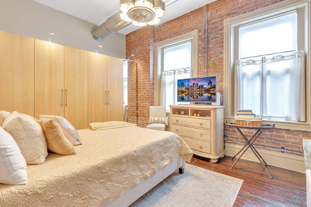 5202 Butler Street, Unit 1 Pittsburgh, PA 15201 - Photo 21 of 28 a bedroom with a bed and a chandelier