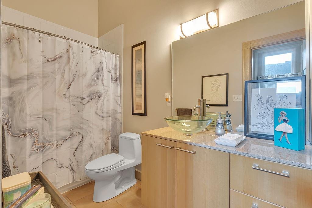 5202 Butler Street, Unit 1 Pittsburgh, PA 15201 - Photo 22 of 28 a bathroom with a granite countertop sink a toilet and a mirror