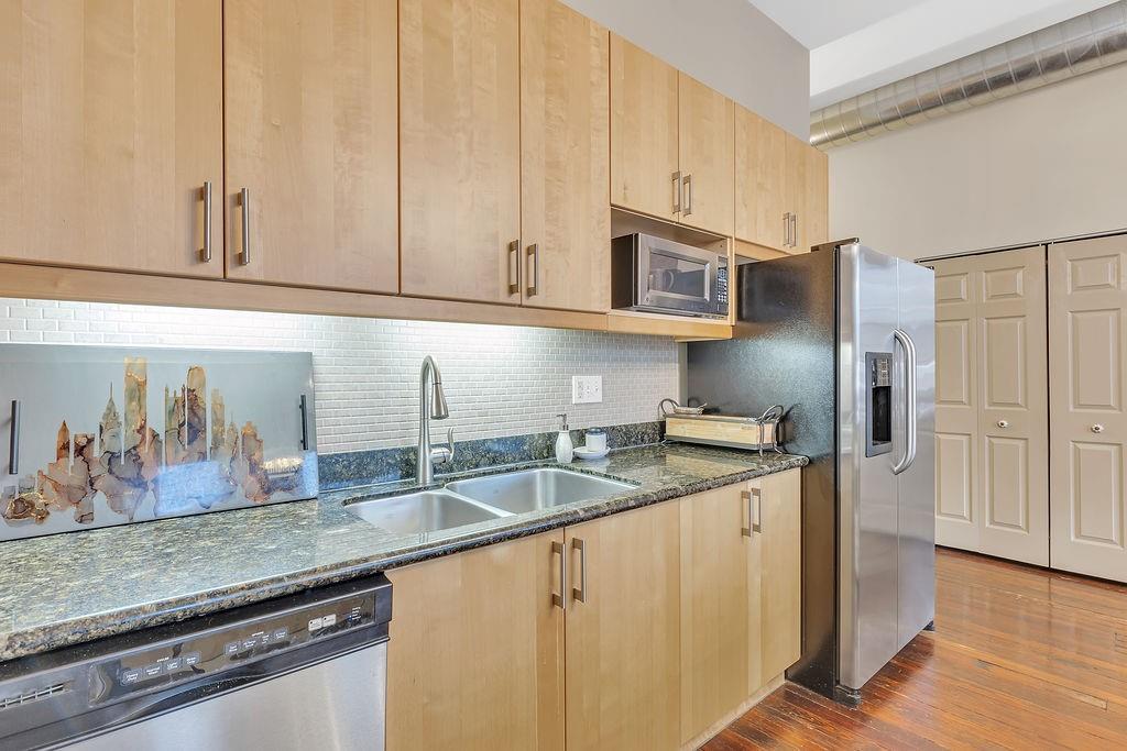 5202 Butler Street, Unit 1 Pittsburgh, PA 15201 - Photo 9 of 28 a kitchen with stainless steel appliances granite countertop a sink and a refrigerator