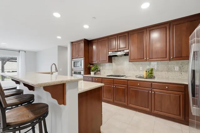 a kitchen with kitchen island granite countertop a sink cabinets and window