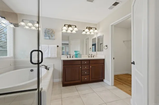 a spacious bathroom with a sink a mirror and a bathtub
