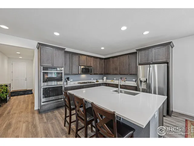 a kitchen with stainless steel appliances granite countertop a stove a sink a table and chairs