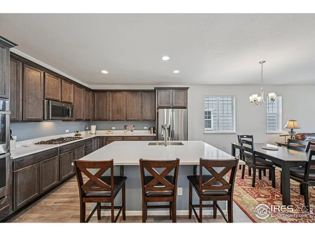 a kitchen with stainless steel appliances granite countertop a sink a stove and a refrigerator