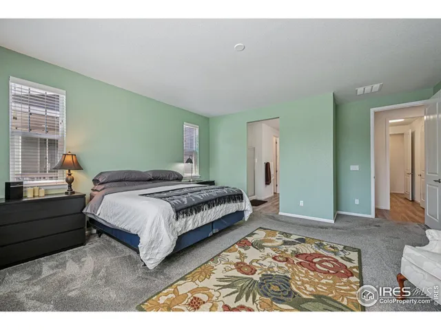 a bedroom with a bed a couch and a window