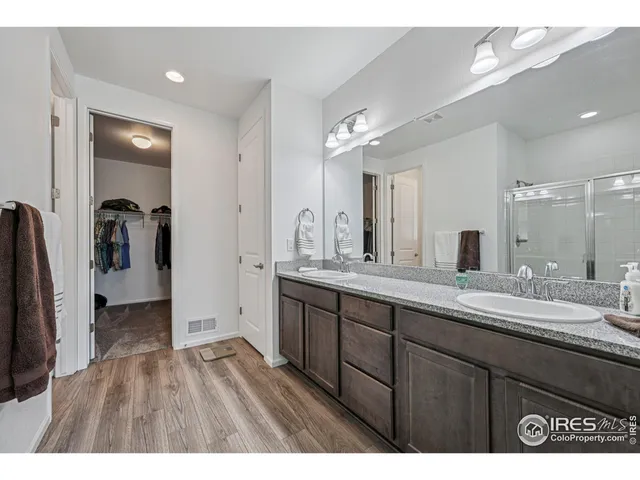 a en suite bathroom with a granite countertop sink and a mirror