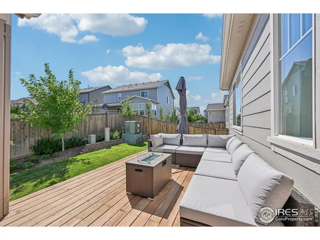 a view of a patio with couches and a table and chairs with wooden fence