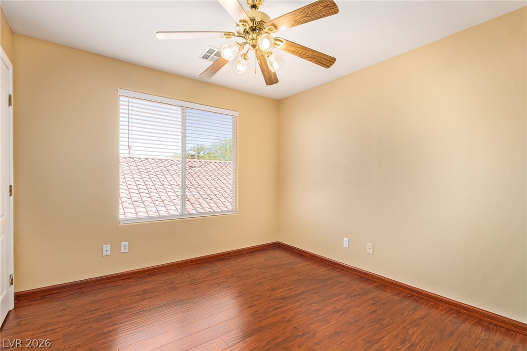 1477 Rancho Ridge Drive Henderson, NV 89012 - Photo 33 of 46 Hardwood flooring extends throughout this versatile room, illuminated by natural light and a ceiling fan.