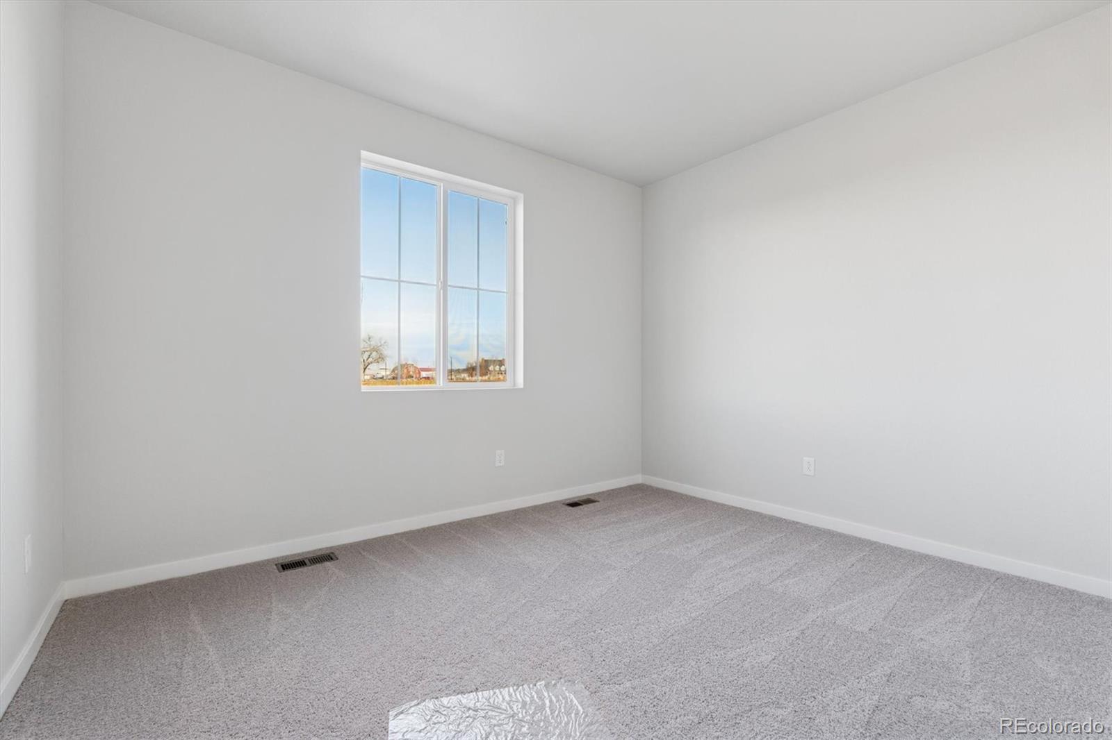 1446 Farmstead Street Brighton, CO 80601 - Photo 15 of 26 an empty room with a window