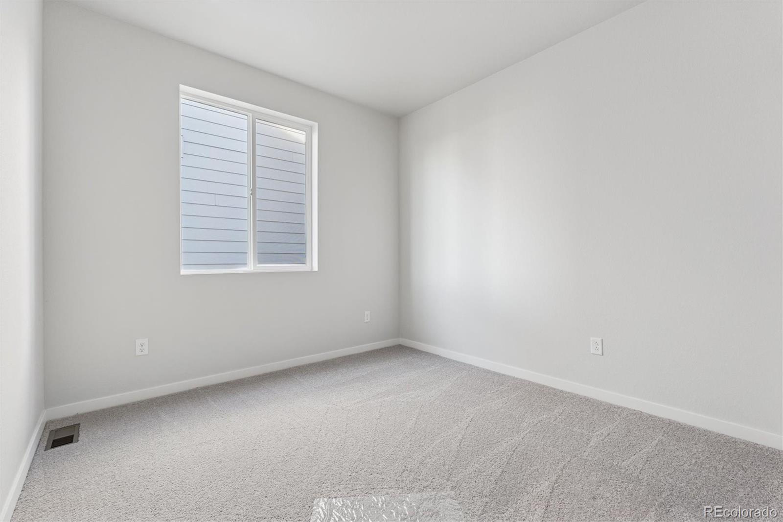 1446 Farmstead Street Brighton, CO 80601 - Photo 18 of 26 an empty room with a window