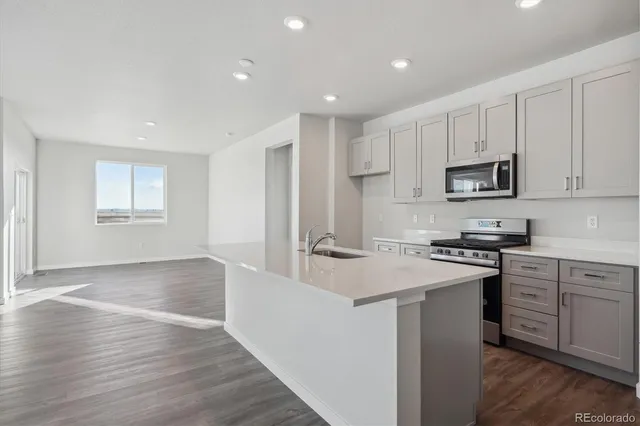 a kitchen with stainless steel appliances granite countertop a stove a sink and a refrigerator