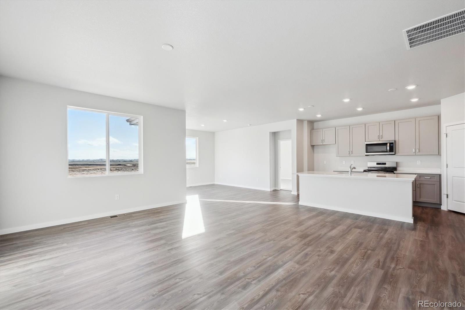 1446 Farmstead Street Brighton, CO 80601 - Photo 5 of 24 a view of kitchen with wooden floor and window