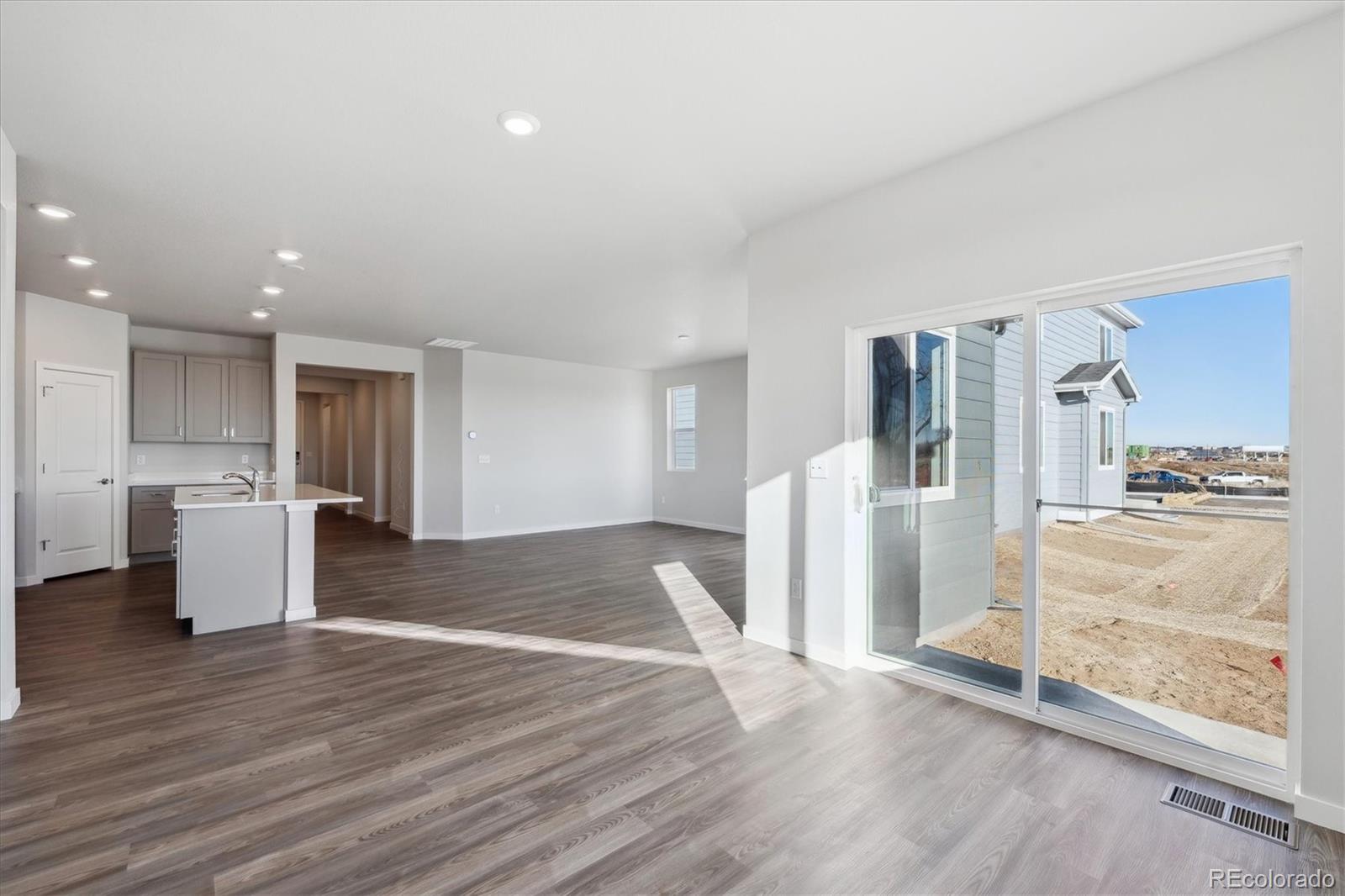 1446 Farmstead Street Brighton, CO 80601 - Photo 7 of 24 a view of a kitchen with wooden floor and a refrigerator